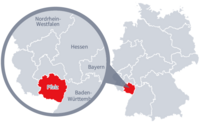 Diese Grafik zeigt eine Karte von Deutschland mit einer detaillierten Ansicht der Region Pfalz. Pfalz ist in Rot hervorgehoben und liegt im südwestlichen Teil Deutschlands. Ein Lupensymbol vergrößert diesen Bereich, um die Lage genauer darzustellen. 